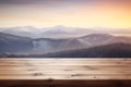 wooden table top against the backdrop of winter snowy high mountains at sunset