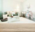 Wooden table top with blur of living room in modern interior style Royalty Free Stock Photo