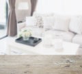 Wooden table top with blur of modern living room design with sofa