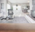 Wooden table top with blur of modern living room interior Royalty Free Stock Photo