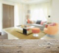 Wooden table top with blur of modern living room interior with orange tone