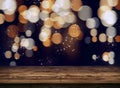 Wooden table top on a golden bokeh abstract background. Glittering particles of gold in the dark night. Wonderful fairytale