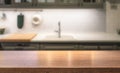 Wooden table top on kitchen island in front of blurred home interior. Royalty Free Stock Photo