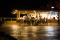 Wooden table top over abstract blur background of people dinner party at outdoor restaurant Royalty Free Stock Photo