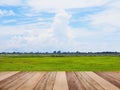 Wooden table top over green grass field and blue sky Royalty Free Stock Photo