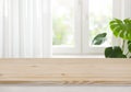 Wooden table top for product display over blurred curtained window Royalty Free Stock Photo