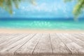 Wooden table top summer time tropical blurry seascape with blurry palm leaves and bokeh against blue sky Summer beach Advertisment Royalty Free Stock Photo