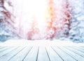 Wooden table top on winter sunny landscape with fir trees