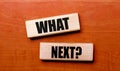 On a wooden table are two wooden blocks with the text question WHAT NEXT Royalty Free Stock Photo