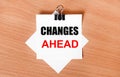 On a wooden table under a black paper clip lies a sheet of white paper with the text CHANGES AHEAD Royalty Free Stock Photo
