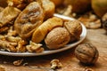 Dried fig and whole and cracked walnuts on white ceramic plate Royalty Free Stock Photo