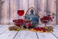 Vase with ripe cherries, jug and glass of wine, yellow maple leaves lie on wooden table. Royalty Free Stock Photo