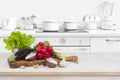 Wooden table with vegetables on top over blurred kitchen interior Royalty Free Stock Photo