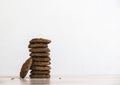 On a wooden table on a white background stands a stack of oatmeal cookies sunflower seeds