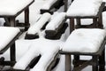 Wooden tables and benches under snow at winter time Royalty Free Stock Photo