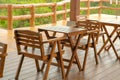 Wooden tables and chairs at outdoor cafe terrace in park. Empty garden furniture surrounded by green garden Royalty Free Stock Photo