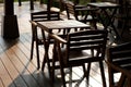 Wooden tables and chairs at outdoor cafe terrace in park. Empty garden furniture surrounded by green garden Royalty Free Stock Photo