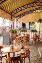 Wooden tables and chairs under a canopy near the old cafe Royalty Free Stock Photo