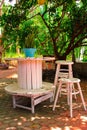 Wooden tables and chairs under a tree.