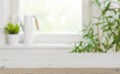 Wooden tabletop with copy space over blurred kitchen window background