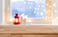 Wooden tabletop over blurred christmas lights on frosted window background