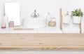 Wooden tabletop for product display over defocused bathroom interior background