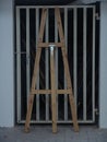 Wooden tall easel standing against a metal garage door in white