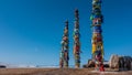 Wooden tall pillars, standing in a row, are tied with multi-colored ritual ribbons