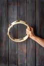 Wooden tambourine in hand. Percussion musical instrument, top view
