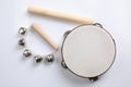 Wooden tambourine, rhythm stick and hand bells on white background, top view. Montessori musical toy Royalty Free Stock Photo