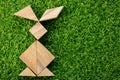 Wooden tangram puzzle in rabbit shape on artificial green grass Royalty Free Stock Photo