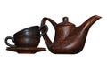 Wooden teapot with two cups in each other stand in saucers isolated on a white background. Royalty Free Stock Photo