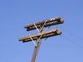 Wooden telephone pole on a blue sky background Royalty Free Stock Photo