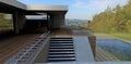 Wooden terrace of a contemporary suburban house with pool on the hilly area. Concrete stair case. Wall finishing is facade board. Royalty Free Stock Photo