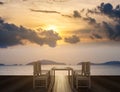 Wooden terrace with dining table and chairs on tropical ocean view in sunset