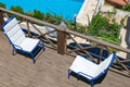 Wooden terrace of holiday villa or hotel with two white chair and sea and pool view Royalty Free Stock Photo