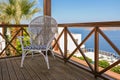 Wooden terrace of holiday villa or hotel with vintage chair and sea view Royalty Free Stock Photo