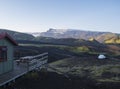 Wooden terrace and white tent in Botnar campsite at Iceland on Laugavegur hiking trail, green valley in volcanic landscape with