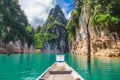 Wooden Thai traditional long-tail boat on a lake with mountains at Ratchaprapha Dam or Khao Sok National Park Royalty Free Stock Photo