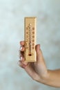 Wooden thermometer in hand Royalty Free Stock Photo
