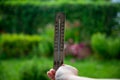 Wooden thermometer in a woman`s hand. Extreme hot weather