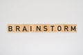 Wooden tile spelling the word brainstorm isolated on a white background