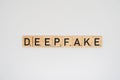 Wooden tile spelling the word deepfake isolated on a white background