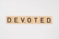 Wooden tile spelling the word devoted isolated on a white background