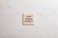 Wooden tile with a Stop animal cruelty sign on it