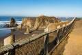 Wooden timber log walkway railing along ocean trail view.