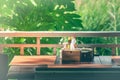 Wooden tissue box and garnish in basket salt, pepper, toothpick, sauce on table with green trees and sunlight background.