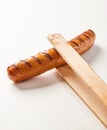 Wooden tongs holding a seared Krakauer polish sausage Royalty Free Stock Photo
