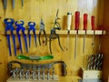 Wooden tool cabinet filled with technician equipment in home workshop.