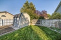 Wooden tool shed with double door at the fenced backyard of a house